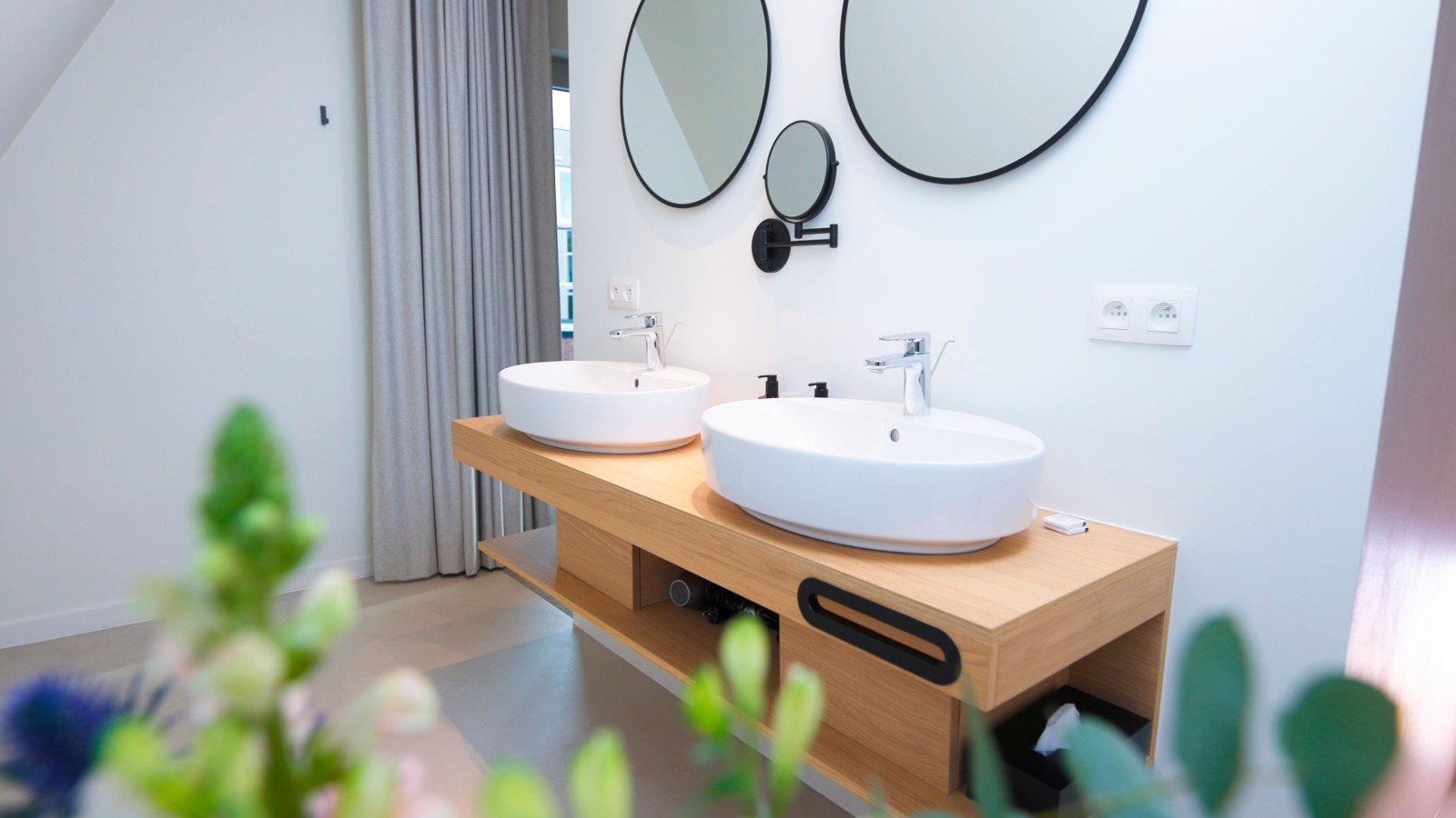 Hotelgast geniet van een Geberit VariForm wastafel met Option spiegel Hotelgast geniet van een Geberit VariForm wastafel met Option spiegel