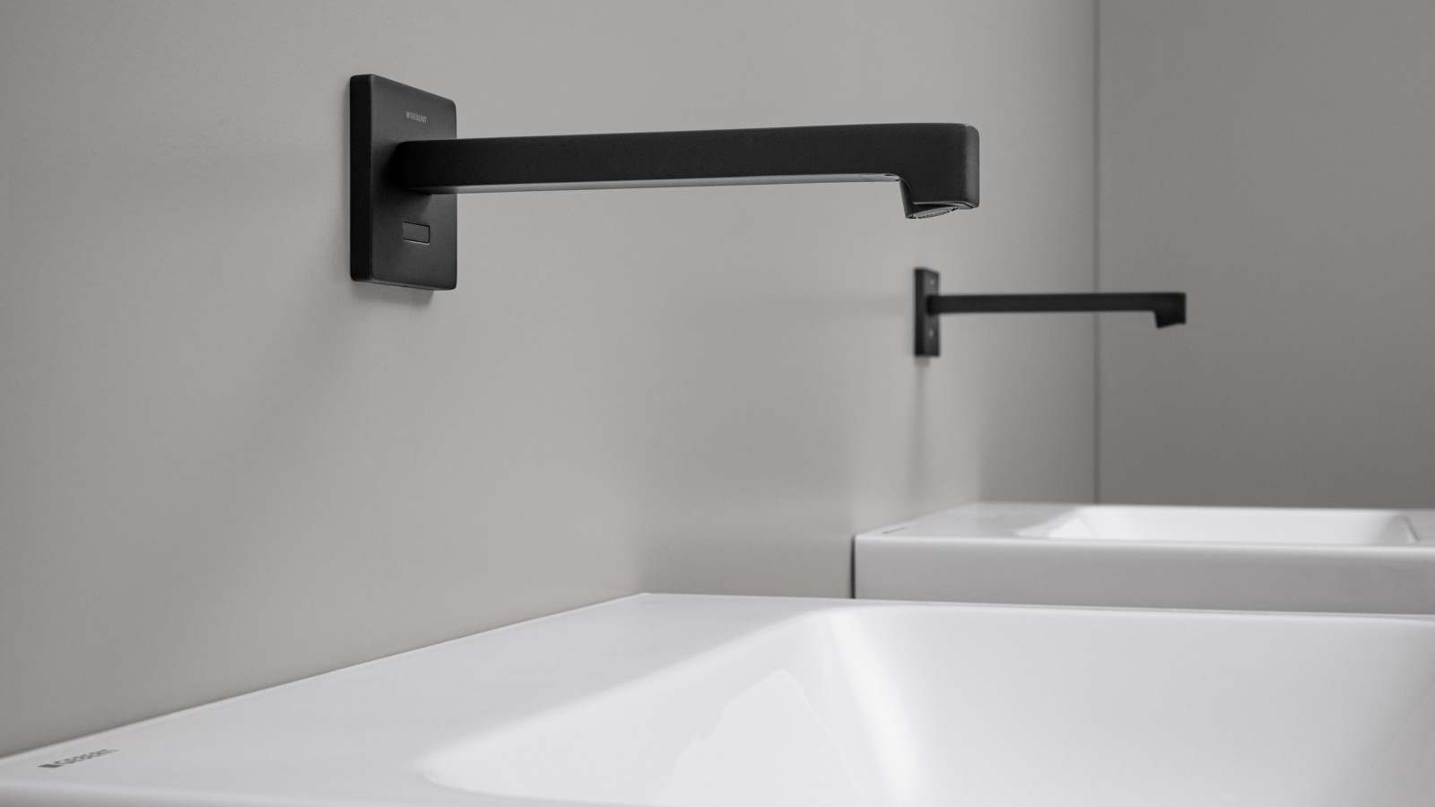 Robinet de lavabo sans contact Geberit Brenta. Robinet mural au design carré en noir mat. Robinet de lavabo sans contact Geberit Brenta. Robinet mural au design carré en noir mat.