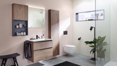 Een wastafelopstelling met badkamermeubilair, wastafel en spiegelkast van Geberit voor een pastelkleurige muur