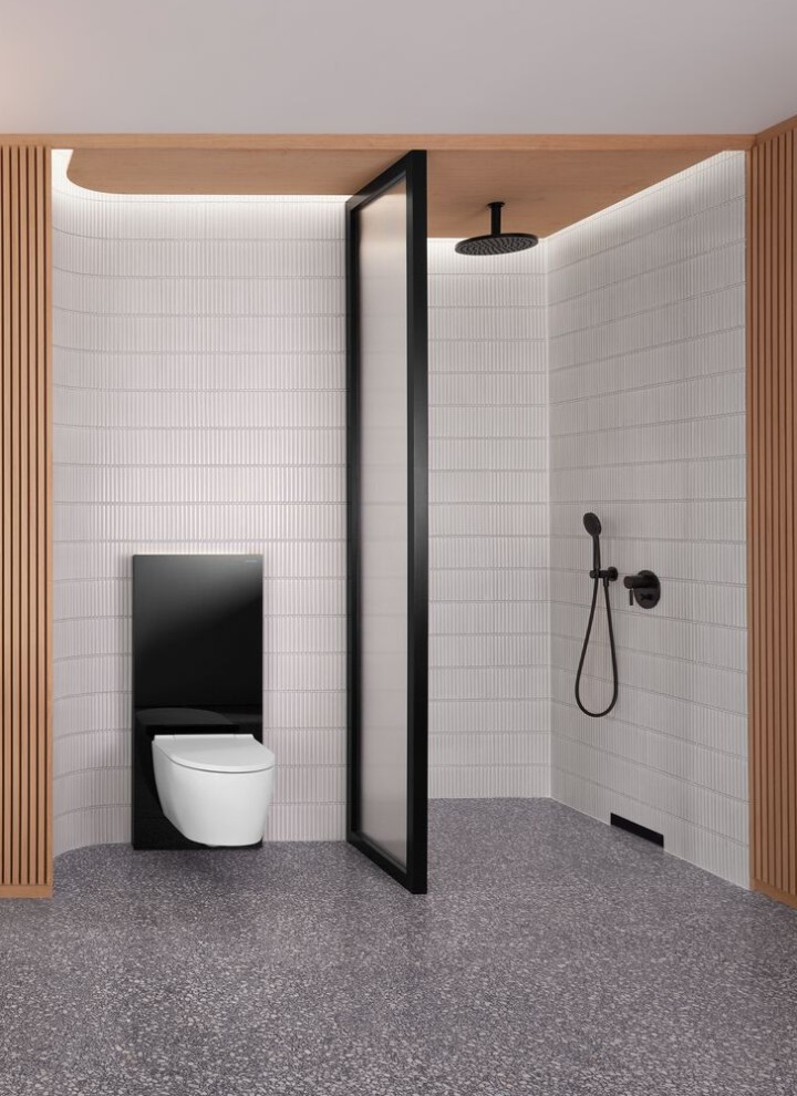 Een badkamer met een houten wand en een douche- en wc-opstelling in zwart-wit