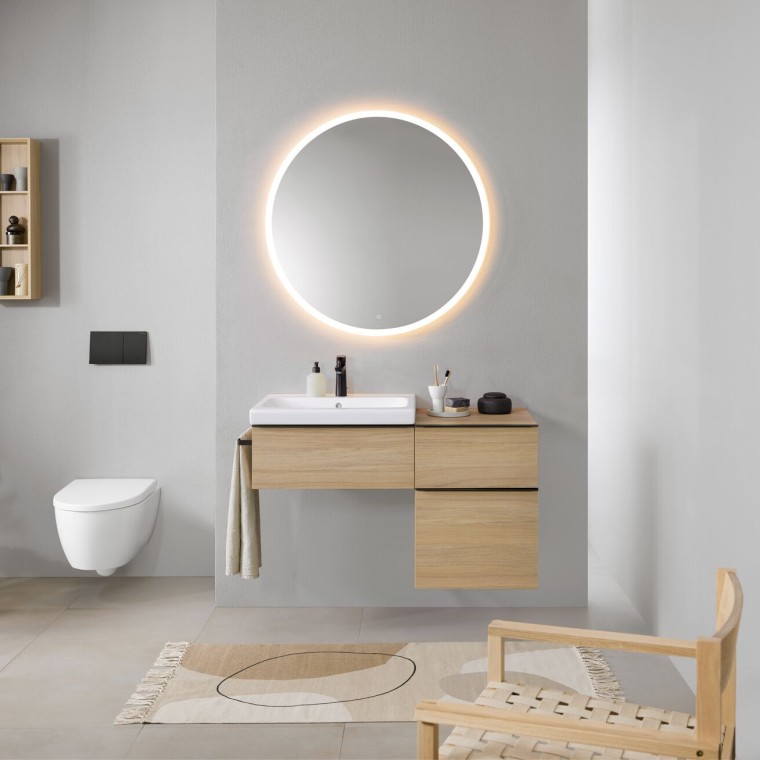 Salle de bains avec murs gris, meubles de salle de bains Geberit en bois et miroir rond Geberit Option éclairé Salle de bains avec murs gris, meubles de salle de bains Geberit en bois et miroir rond Geberit Option éclairé