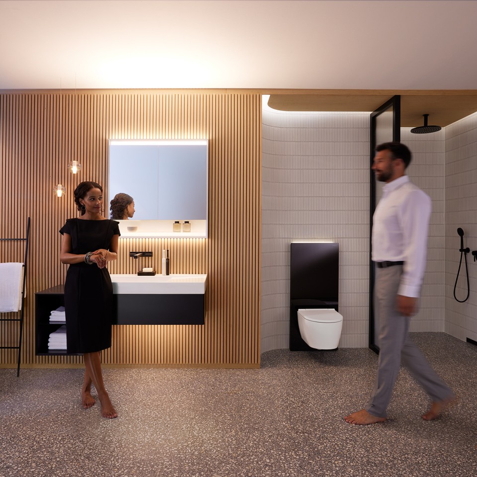 Man en vrouw in perfect verlichte badkamer met Geberit ONE badkamermeubilair en sanitaire keramiek (© Geberit)