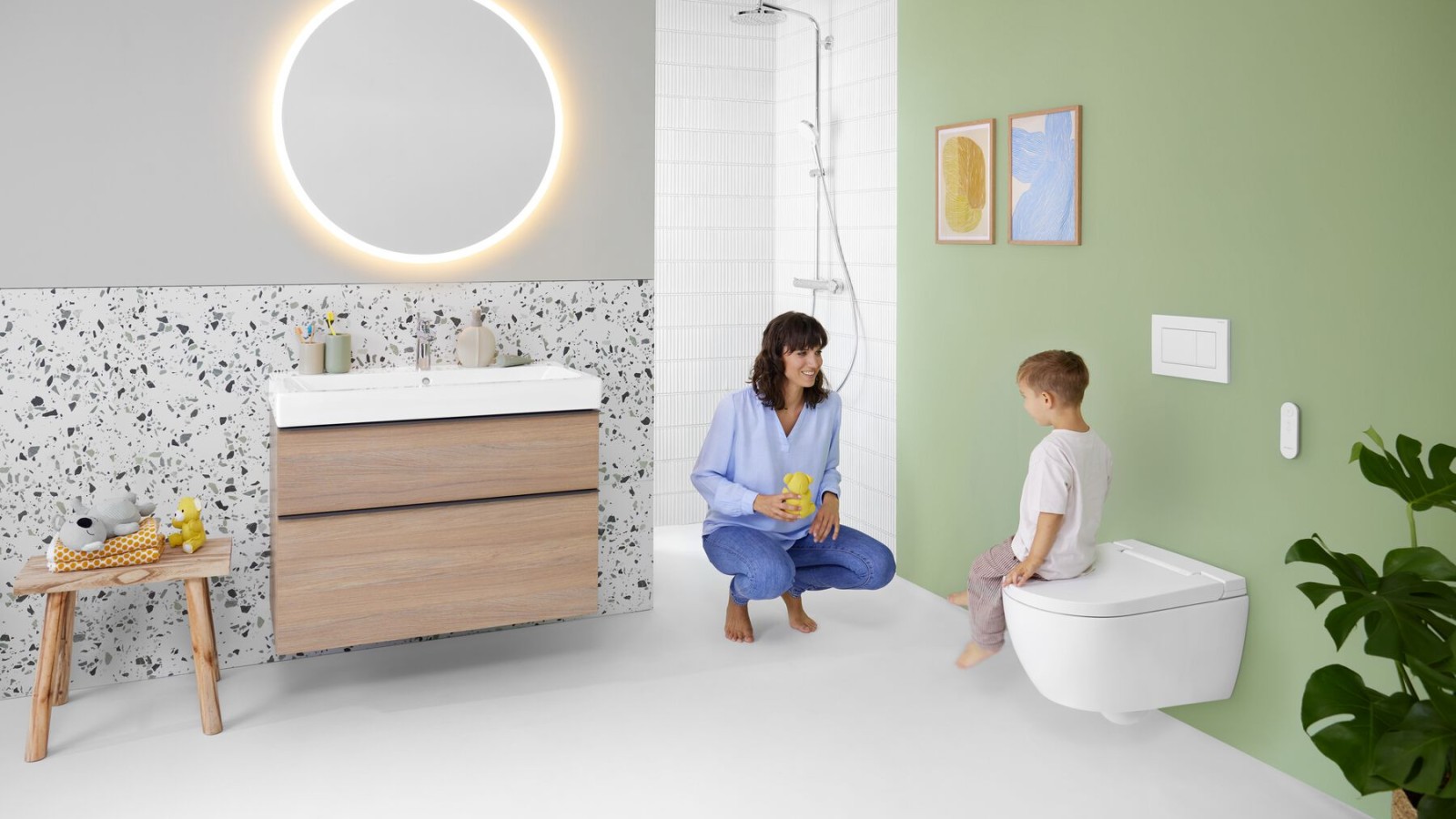 Vrouw en kind in een kleurrijke badkamer met Geberit Option spiegel en Geberit AquaClean Alba Vrouw en kind in een kleurrijke badkamer met Geberit Option spiegel en Geberit AquaClean Alba