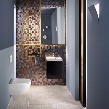 Vue d'un WC d'invités moderne avec un WC Acanto et un lavabo Acanto devant un dosseret en mosaïque