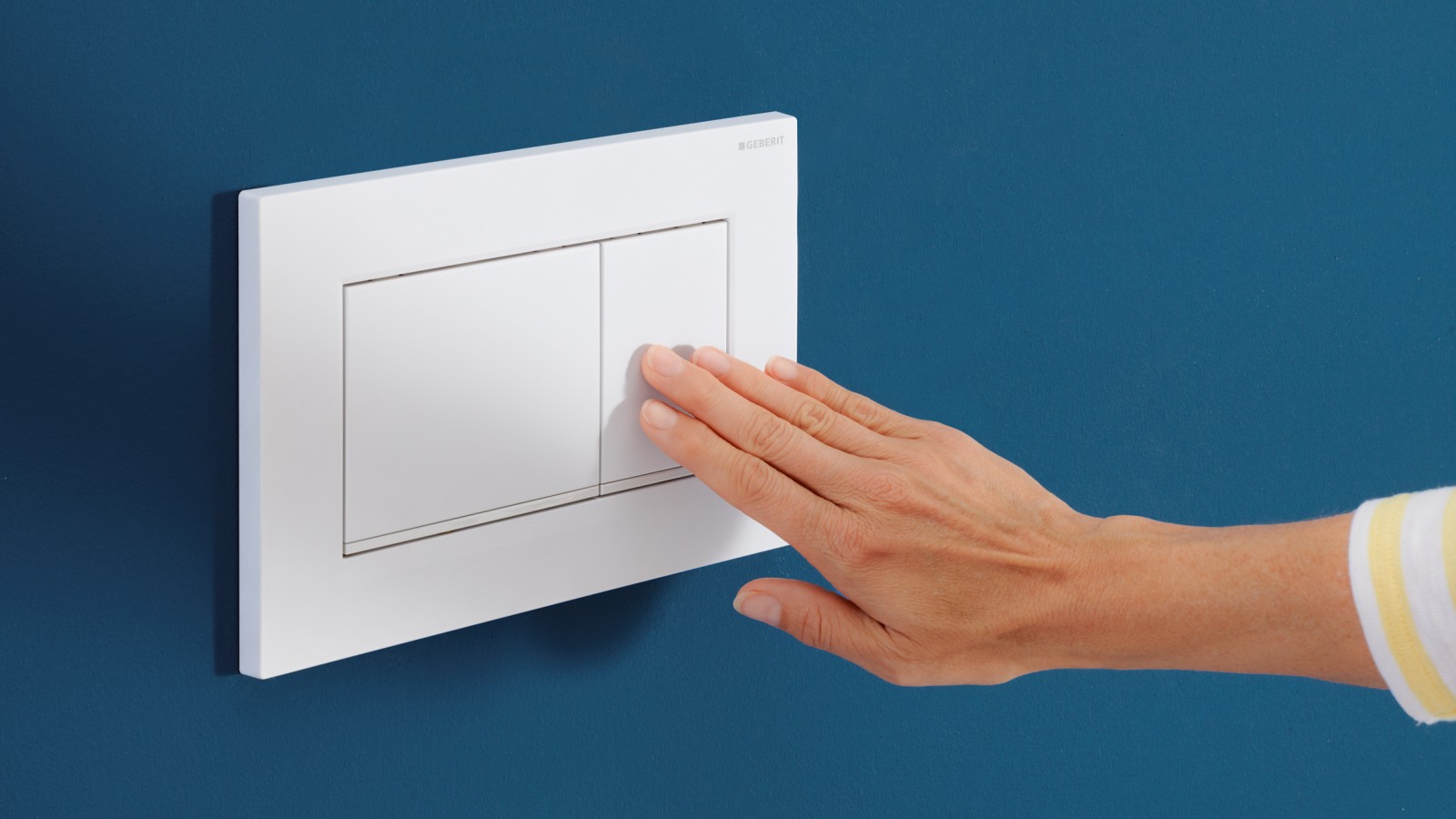 De persoon drukt op het kleine knopje op de witte bedieningsplaat Sigma30 De persoon drukt op het kleine knopje op de witte bedieningsplaat Sigma30