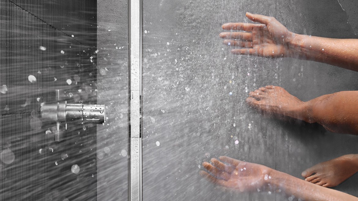 Persoon doucht in een gelijkvloerse douche met Geberit CleanLine douchegoot