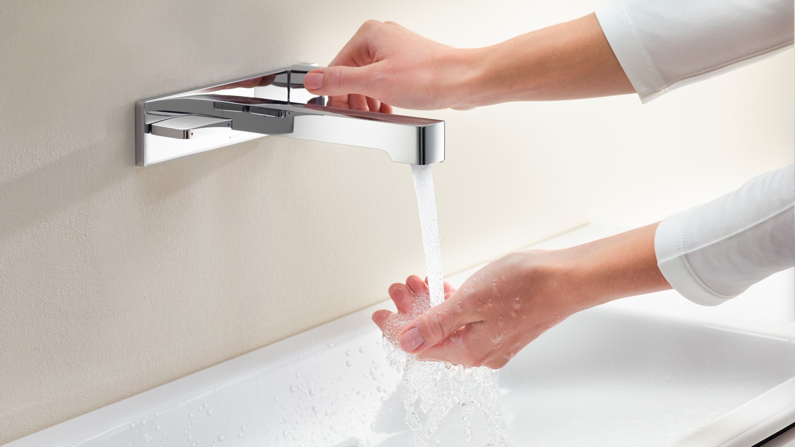 Femme ouvrant le robinet pour vérifier lʼintensité et la température de lʼeau (© Geberit)
