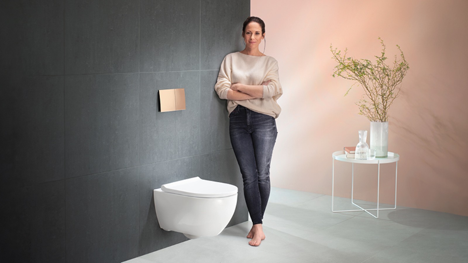 Femme se tenant à côté du système pour WC Geberit Femme se tenant à côté du système pour WC Geberit