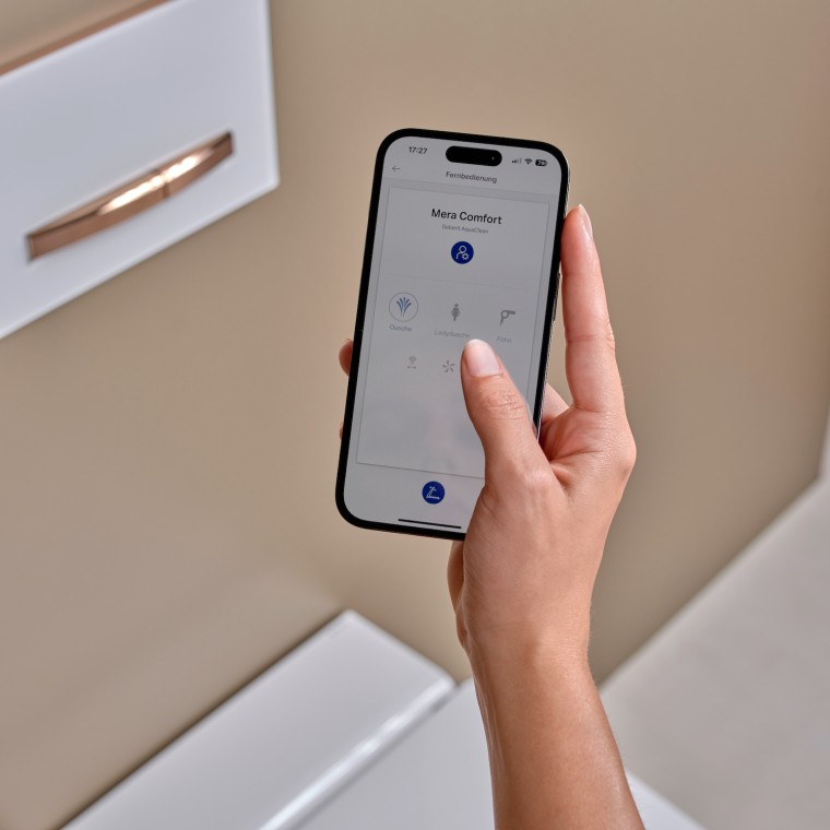 Een vrouw gebruikt de Geberit Home-app op een smartphone Een vrouw gebruikt de Geberit Home-app op een smartphone