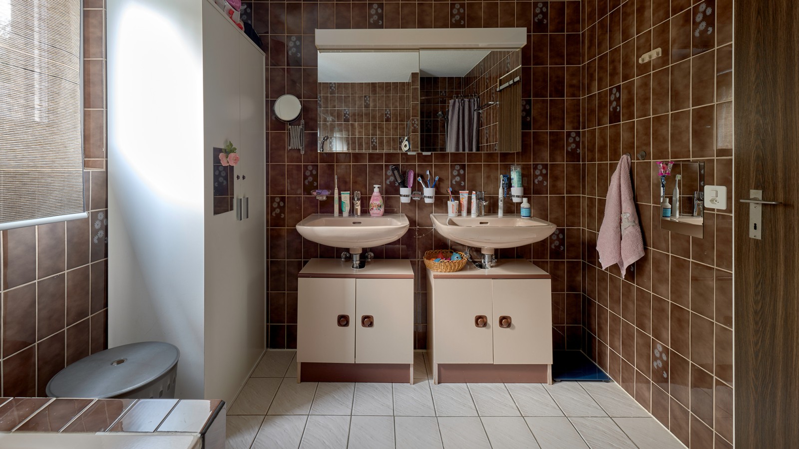 Salle de bains avec carrelage marron et deux lavabos Salle de bains avec carrelage marron et deux lavabos
