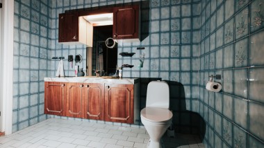 Salle de bains avec carrelage bleu et WC au sol