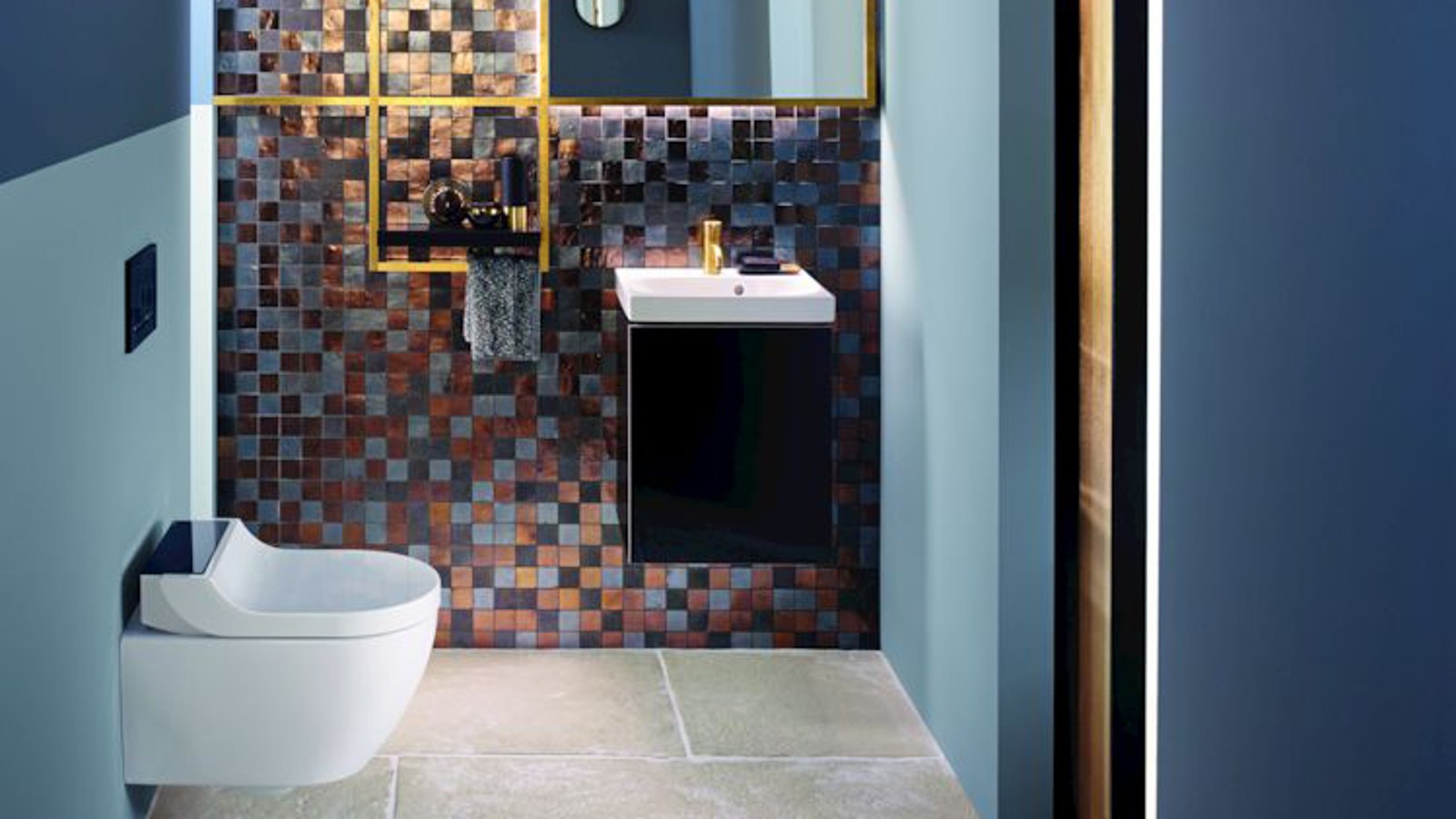 Goud- en kopertinten zorgen voor een warme sfeer in dit gastentoilet Goud- en kopertinten zorgen voor een warme sfeer in dit gastentoilet