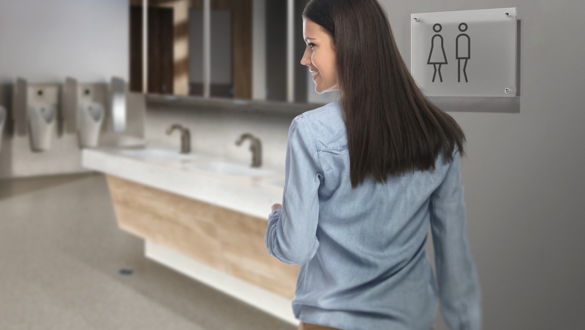 Donkerharige jonge vrouw in een openbaar wc Donkerharige jonge vrouw in een openbaar wc