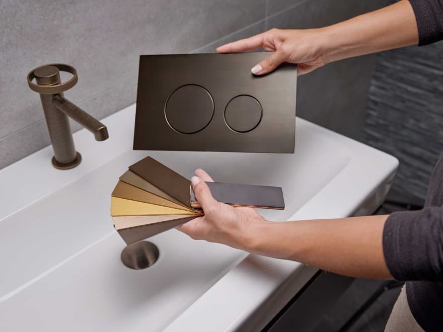 Plaque de commande Geberit Sigma40 assortie au robinet de lavabo en finition métallique « bronze patiné » Plaque de commande Geberit Sigma40 assortie au robinet de lavabo en finition métallique « bronze patiné »