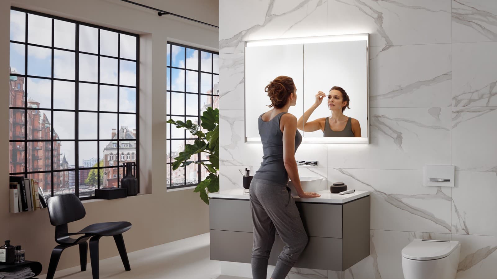 Femme dans une salle de bains avec Geberit ComfortLight Femme dans une salle de bains avec Geberit ComfortLight