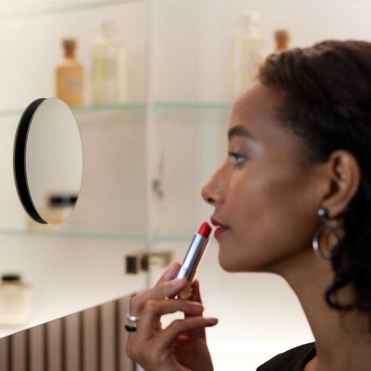 Femme se maquillant devant le miroir Femme se maquillant devant le miroir