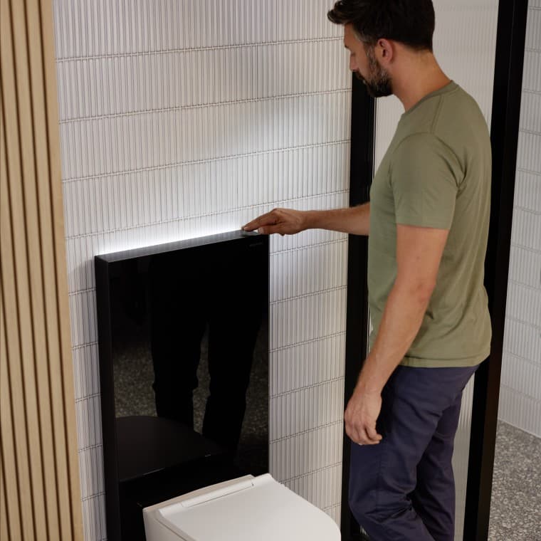 Homme à côté du module sanitaire Geberit Monolith Plus Homme à côté du module sanitaire Geberit Monolith Plus