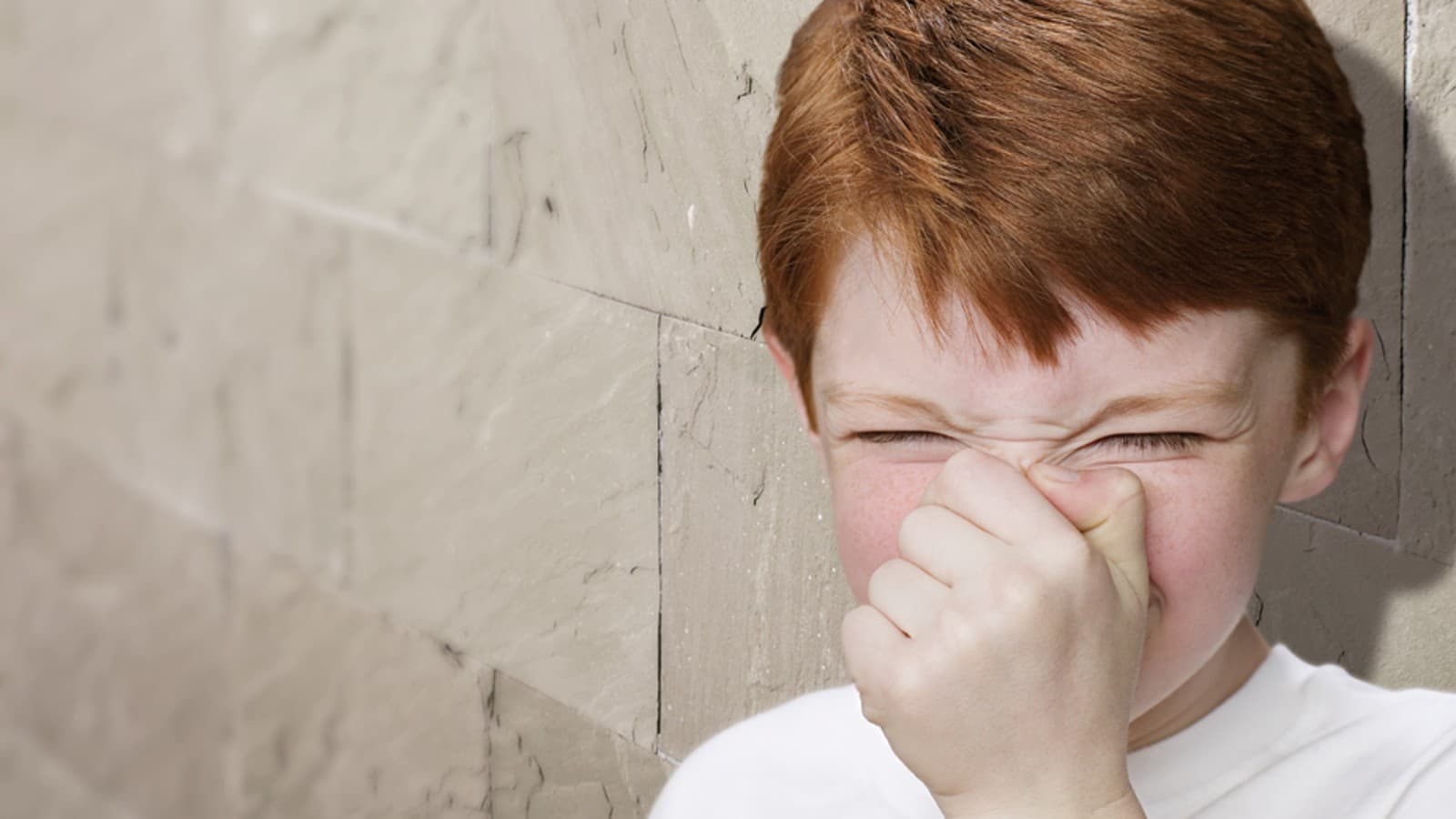 Jeune garçon se bouchant le nez Jeune garçon se bouchant le nez