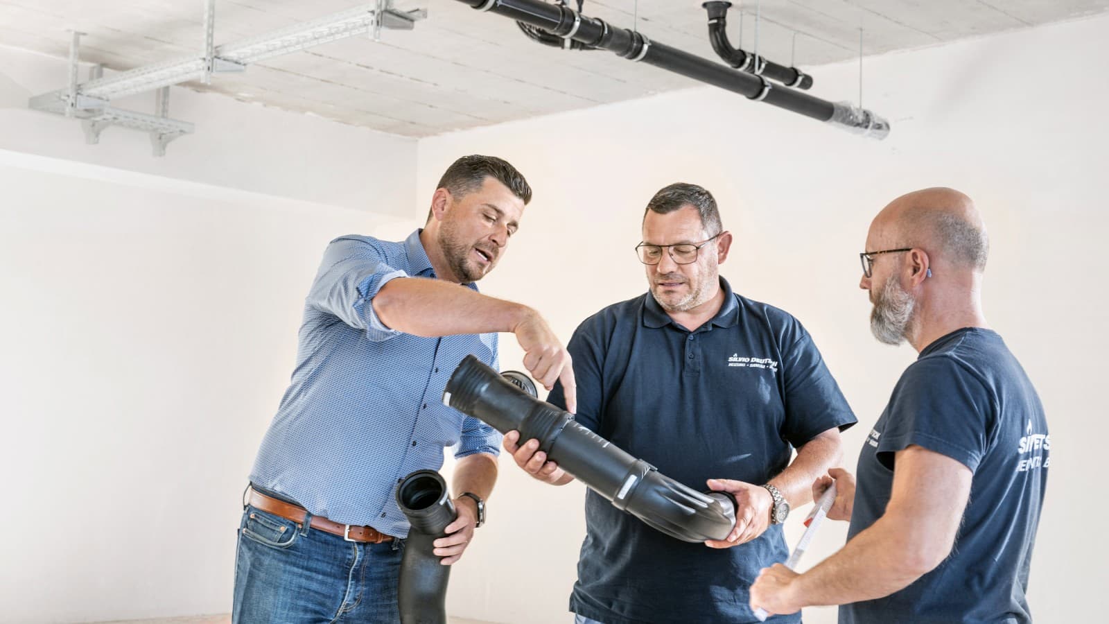 Geberit verkoopadviseur Fabian Ritter geeft aan projectleider Marcel Roth en zijn team uitleg over de nieuwe Geberit Silent-Pro BottomTurn bocht Geberit verkoopadviseur Fabian Ritter geeft aan projectleider Marcel Roth en zijn team uitleg over de nieuwe Geberit Silent-Pro BottomTurn bocht